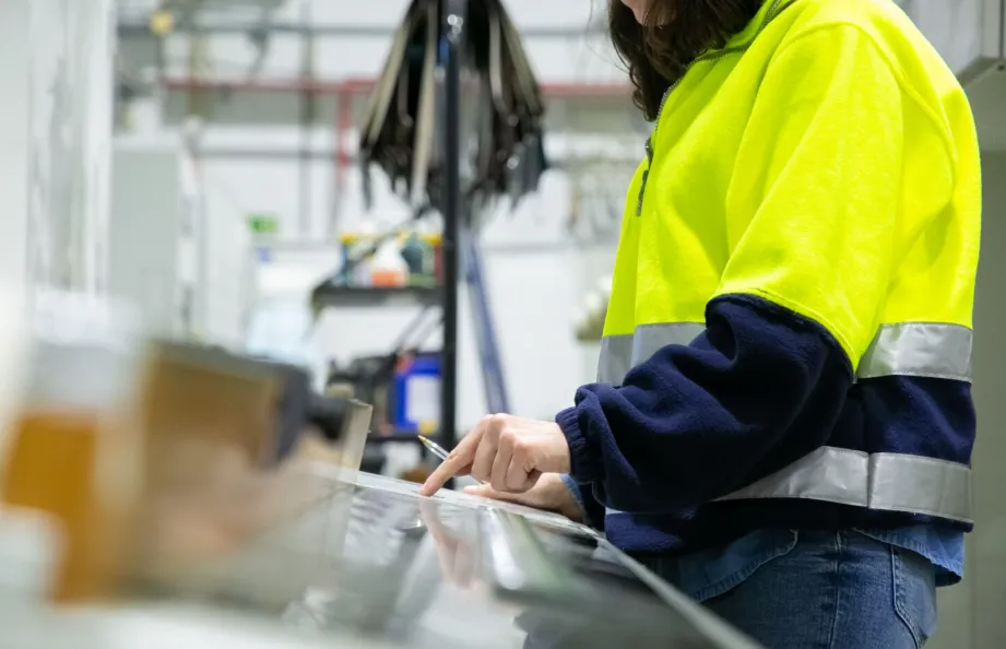 Operator in a high-visibility jacket working at a bench